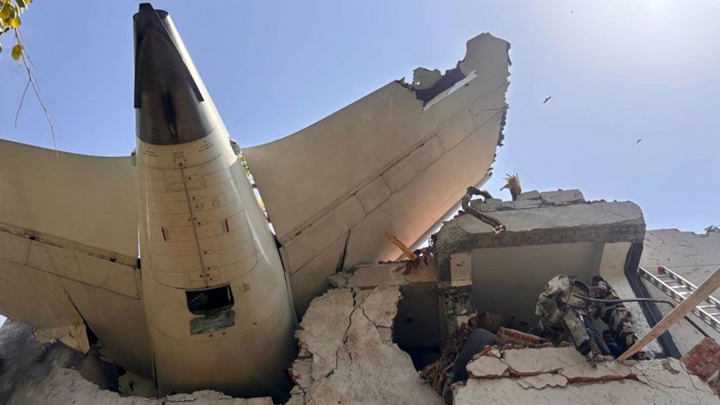 An image from below of the plane lodged in the side of a building in Ahmedabad