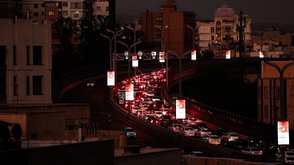 Several lanes stuck in a traffic jam along a stretch of highway in Tehran at night, on 15 June