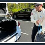 Martin De Anda loading delivery bags into the trunk of his car while wearing Airtasker gear